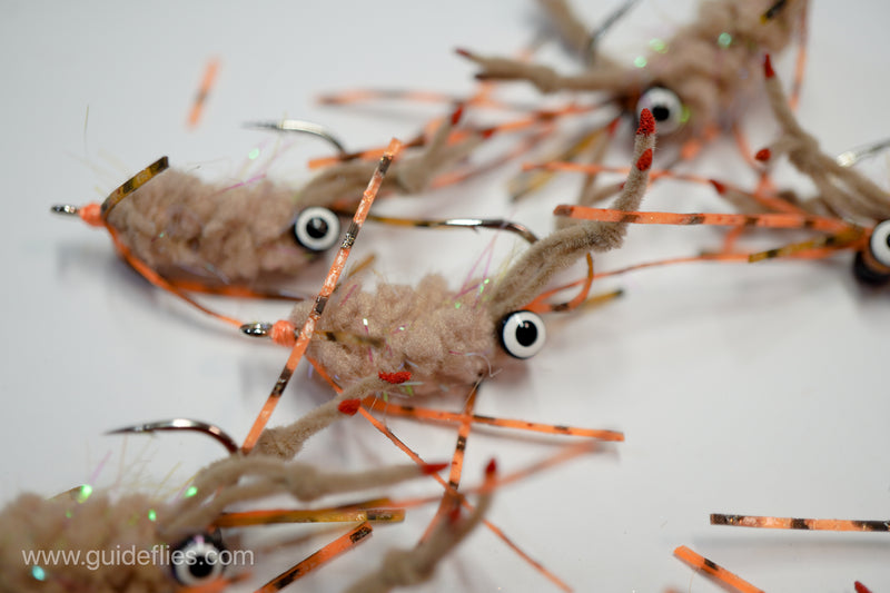 Guard Hair Chenille with contrasting rubber legs and small pearl UV micro tinsel built into a very translucent microfiber tied on Umpqua XS410 Premium Flats Hook this specific fly comes with a black bead eye with white pupils.