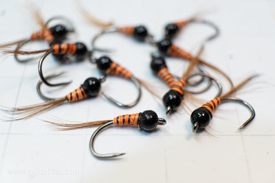 synthetic orange body and a heavy tungsten bead head with an oversized comp hook