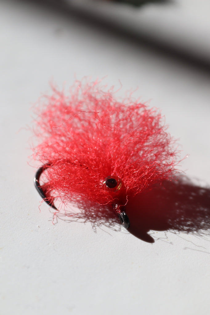 Saltwater fly of colored red with beaded eyes with a size 1 umpqua hook that are great for catching tarpon