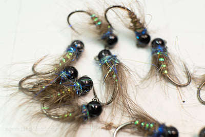Light blue Ice Dub, a CDC soft hackle collar, and hare's ear body tie on a size 14 competitive jig hook with a black tungsten bead head