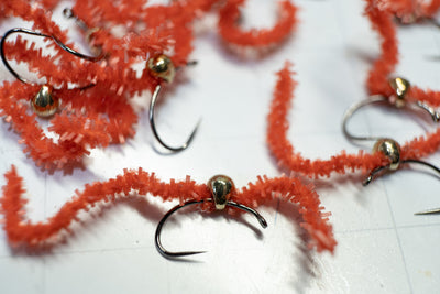 Flies tied with a tear-drop tungsten bead head  and colored with red red chewing gum chenille