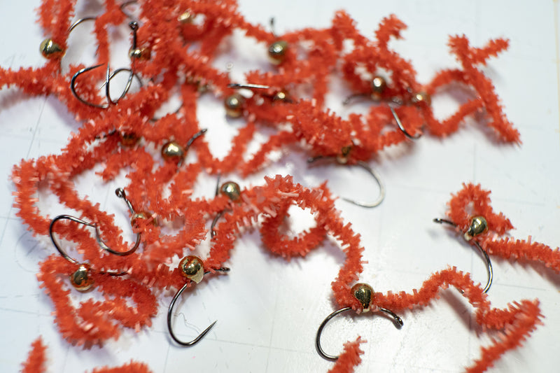 Flies tied with a tear-drop tungsten bead head and colored with red chewing gum chenille
