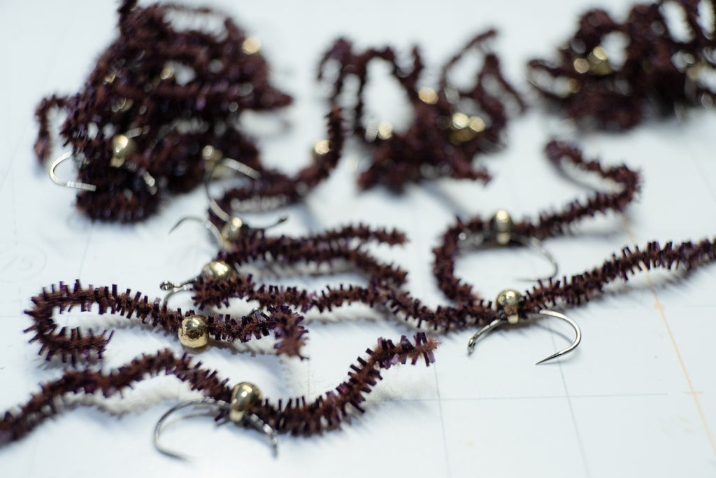 Flies tied with a tear-drop tungsten bead head and colored with black chewing gum chenille