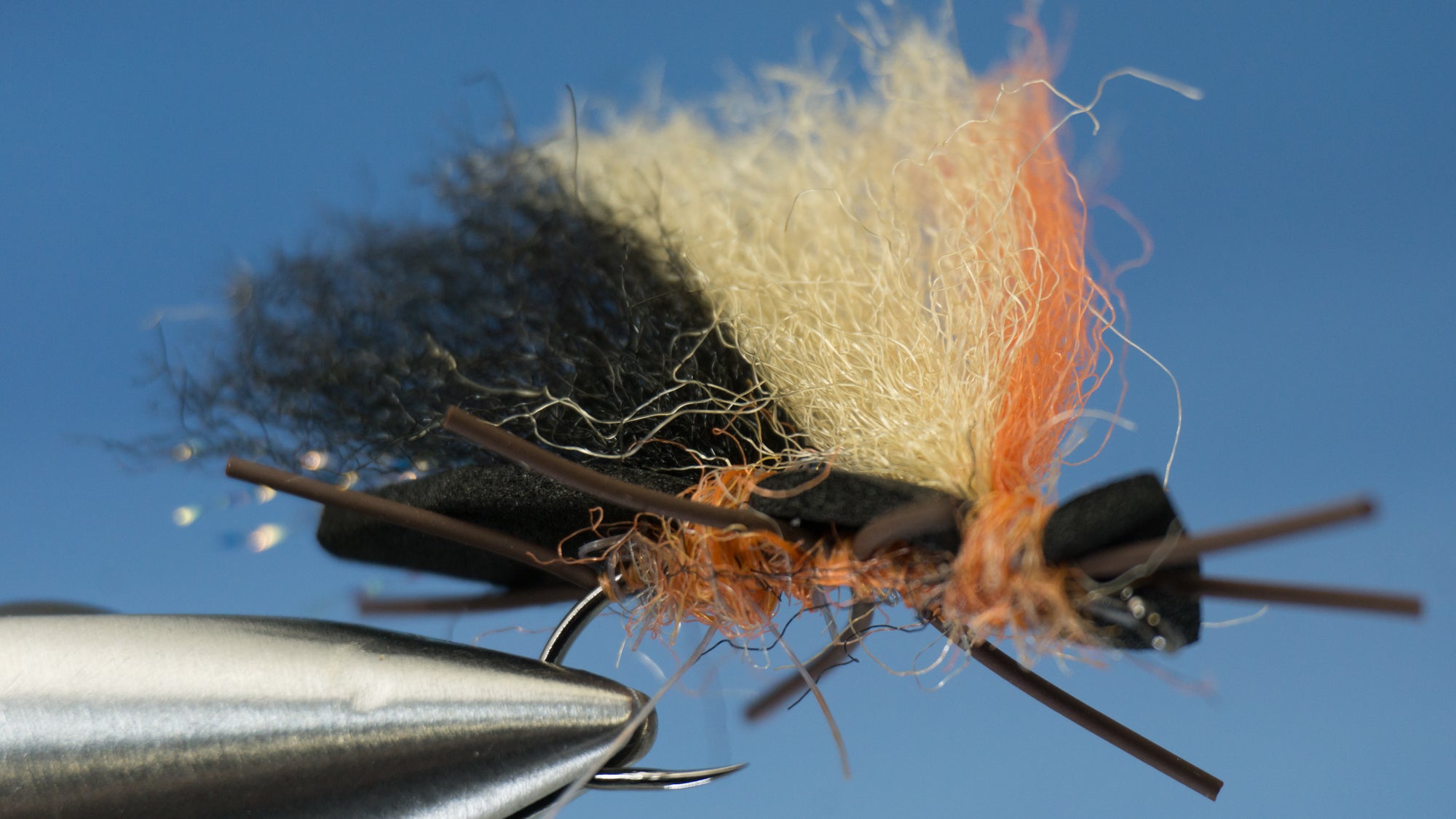 Made with 2 crinkle hair and a firehole outdoor hook colored in orange and black