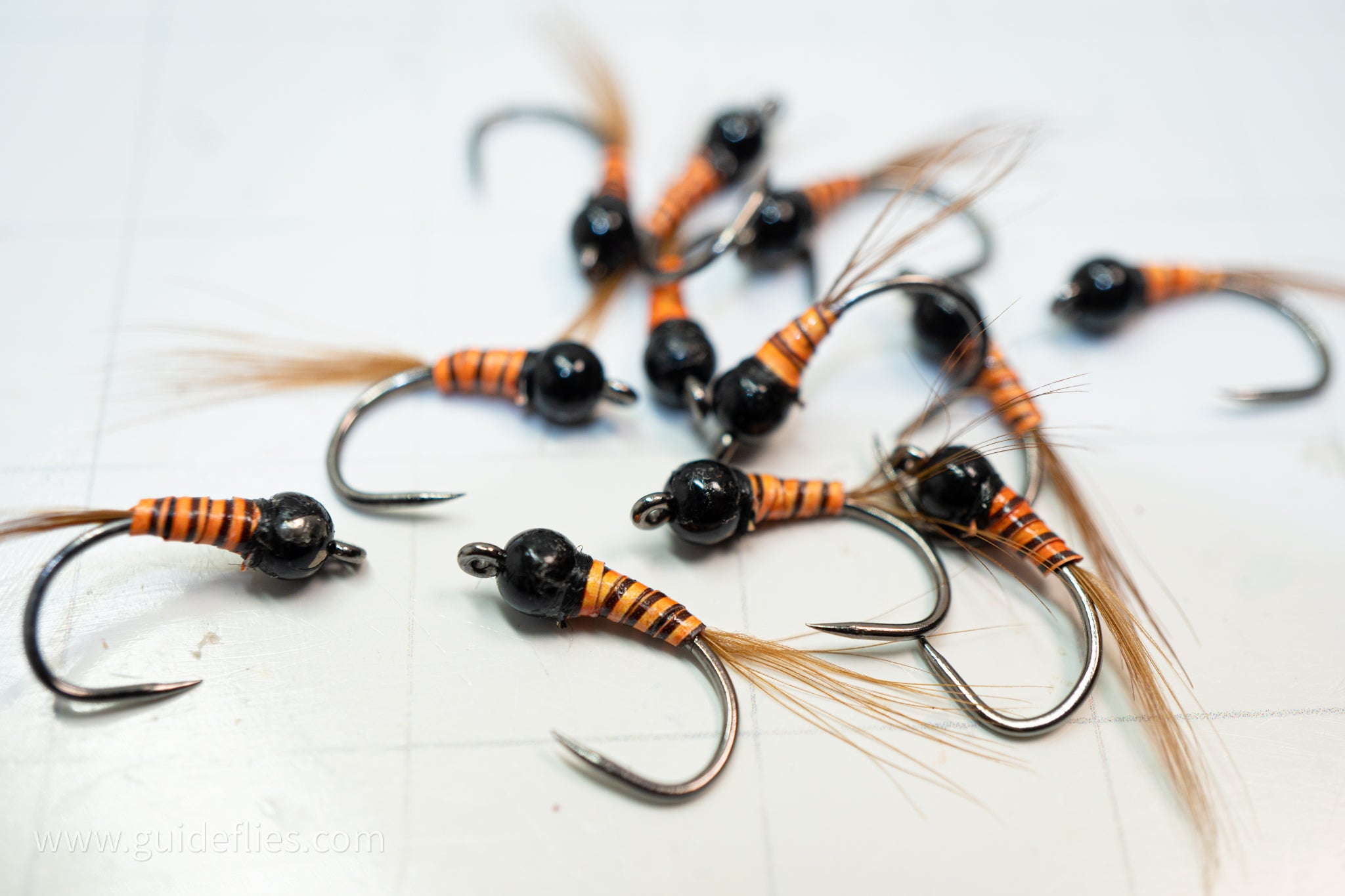 synthetic orange body and a heavy tungsten bead head with an oversized comp hook