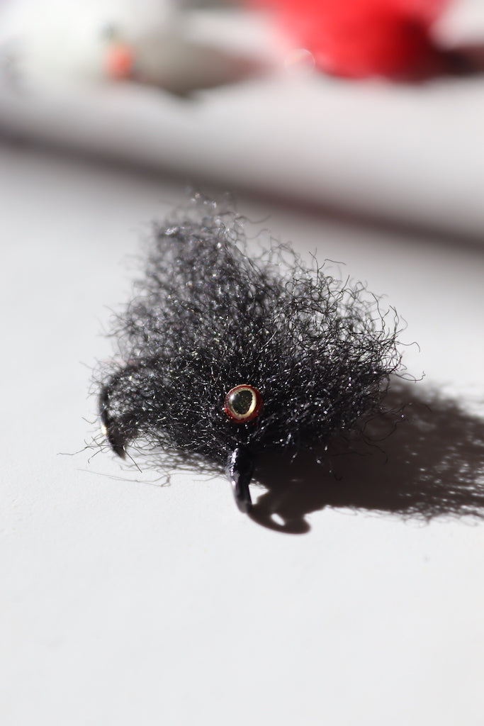 Saltwater fly of colored black with beaded eyes with a size 1 umpqua hook that are great for catching tarpon